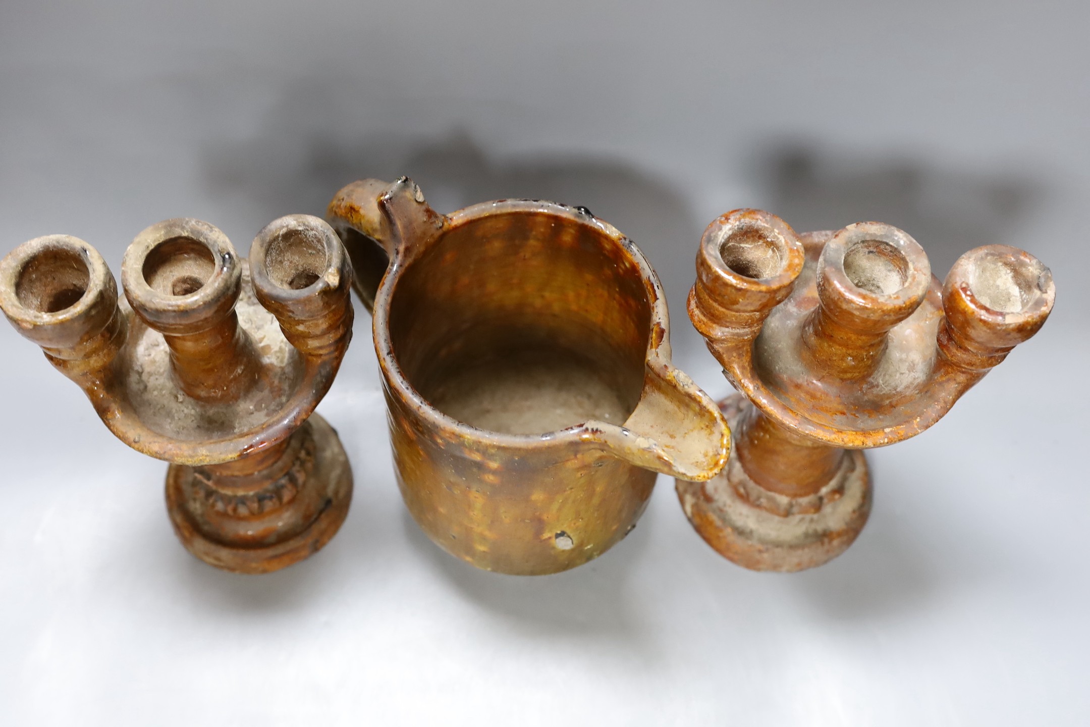 A 19th century rustic pottery jug and a pair of candelabra, 23cm